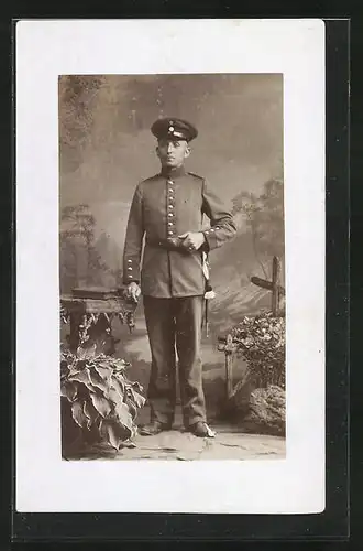 Foto-AK Soldat mit Schirmmütze in Feldgrau mit Portepee und Bajonett, Uniformfoto