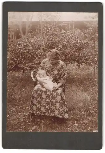 Fotografie unbekannter Fotograf und Ort, Portrait modisch gekleidete Dame mit Kleinkind auf dem Schoss
