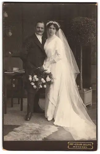 Fotografie Atelier Seiling, München, Prielmayerstrasse 18, Portrait junges Paar in Hochzeitskleidung mit Blumenstrauss