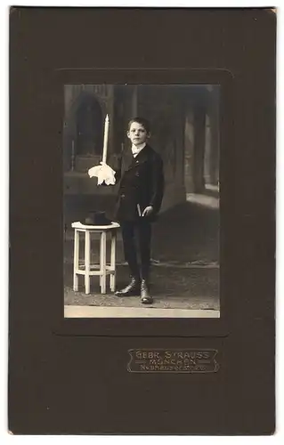 Fotografie Gebr. Strauss, München, Neuhauserstrasse 20, Portrait hübscher Knabe im Anzug mit Kerze