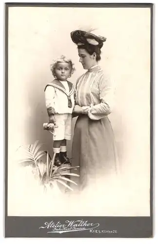 Fotografie Atelier Walther, Kiel, Kline 26, Mutter im Kleid mit ihrem Sohn in Matrosenanzug, Mutterglück