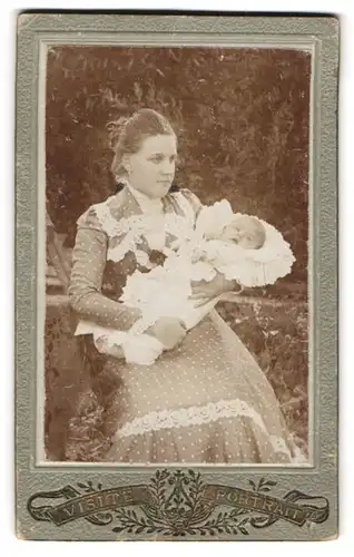 Fotografie A. Illchmann, Pernitz, Portrait junge Mutter im Pünktchenkleid mit Baby im Arm, Mutterglück