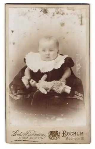 Fotografie Louis Frohmann, Bochum, Hochstr. 19, Portrait Kleinkind im Samtkleid mit Puppe in der Hand