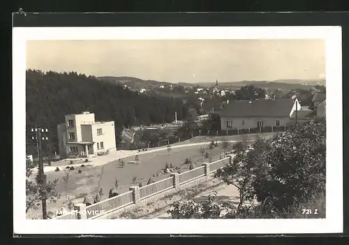 AK Mnichovice, Ortsansicht mit Freibad im Hintergrund