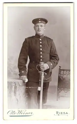 Fotografie Otto Werner, Riesa, Kastanienstrasse 81, Junger Soldat in Uniform mit Säbel und Krätzchen