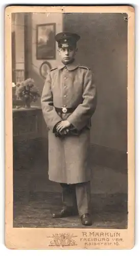 Fotografie R. Märklin, Freiburg i. Br., Kaiserstr. 10, Portrait junger Soldat Willi im Uniformsmantel mit Mütze