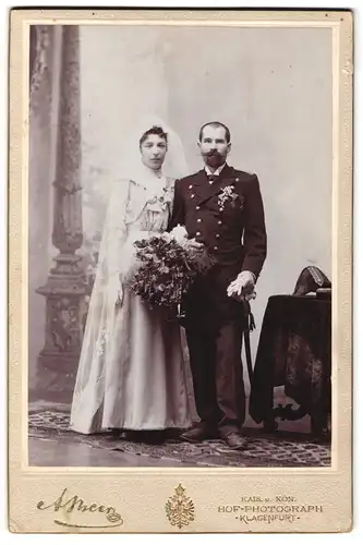 Fotografie Alois Beer, Klagenfurt, Portrait Soldat in Uniform mit Orden und Zweispitz nebst Braut, Kriegshochzeit