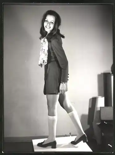 Fotografie Mode der 70er Jahre, junges brünettes Model posiert im kurzen Rock mit Strümpfen