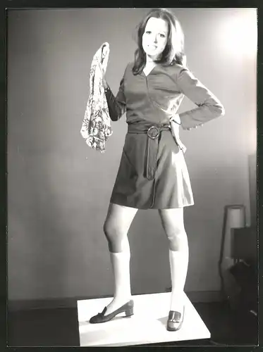 Fotografie Mode der 70er Jahre, junge Brünette im Schulmädchen-Look mit Strümpfen und kurzem Rock