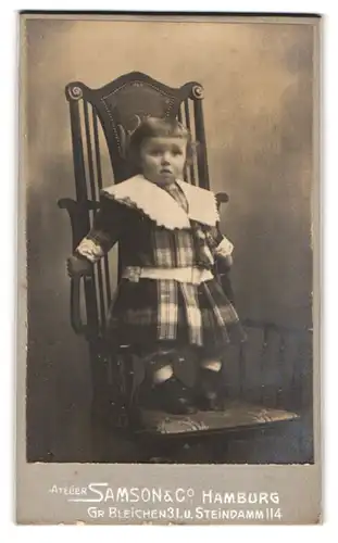 Fotografie Samson & Co., Hamburg, Grosse Bleichen 31, verschrecktes Kind auf Schaukelstuhl stehend
