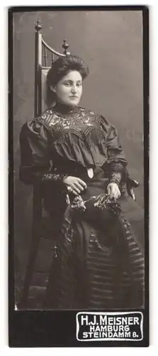 Fotografie H. J. Meisner, Hamburg, Steindamm 8, hübsche junge Dame mit Blume in Hand auf Sessel thronend