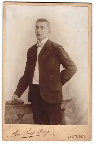 Fotografie Max Reifenberg, Altona, Reichenstrasse 37, Junger Mann im Anzug mit Hand auf Buch