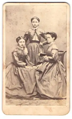 Fotografie Fotograf und Ort unbekannt, Drei Schwestern in feinen Kleidern