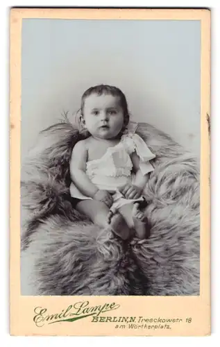 Fotografie Emil Lampe, Berlin, Tresckowstr. 18, niedliches Kleinkind auf Fell sitzend