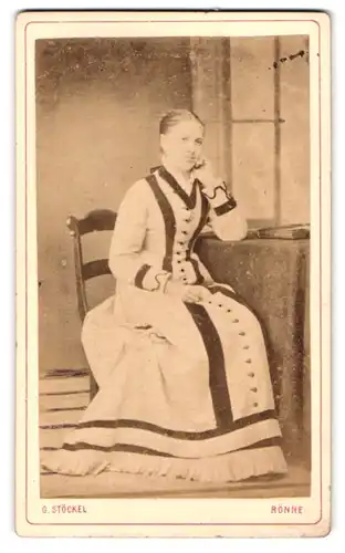 Fotografie G. Stöckel, Rönne, junge Dame in hellem Kleid auf Tisch stützend