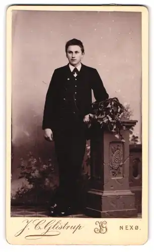 Fotografie J. C. Glistrup, Nexö, junger Mann elegant mit Säule posierend
