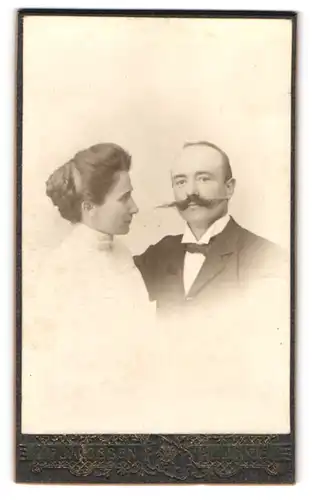Fotografie H.P. Jacobsen, Allinge, junge Dame auf imposanten Schnurrbart ihres Partners schauend