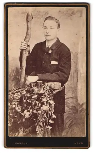 Fotografie J. Hansen, Nexö, Junger Herr im Anzug an Baumstumpf gelehnt