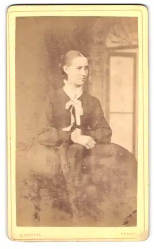 Fotografie G. Stöckel, Rönne, Junge Dame in schwarzem Kleid mit weisser Schleife am Kragen