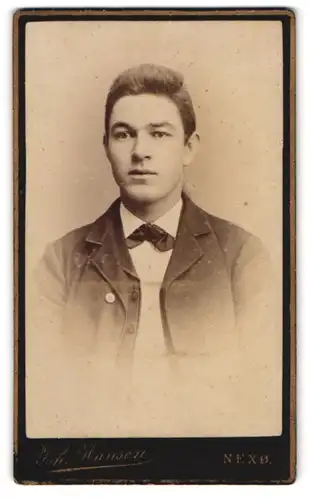 Fotografie Joh. Hansen, Nexö, Portrait eines jungen Mannes im Anzug mit Fliege