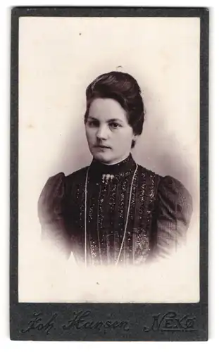 Fotografie Joh. Hansen, Nexö, Schöne junge Dame mit zeitgenössischer Frisur in verziertem Kleid