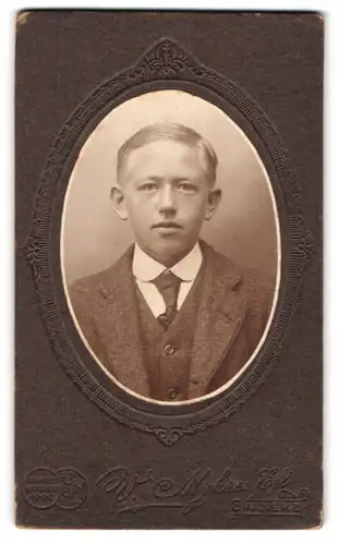 Fotografie V. Myhre, Svaneke, Portrait von jungem Burschen mit Segelohren im Anzug