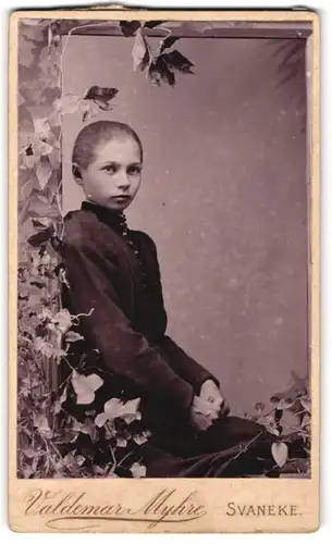 Fotografie Valdemar Myhre, Svaneke, Junges Mädchen in schwarzem hochgeschlossenem Kleid und zurückgebundenem Haar