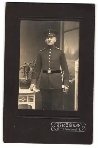 Fotografie Brüère, Metz, Rattenturmstrasse 8, Portrait Soldat in Uniform mit Schirmmütze und Zigarette