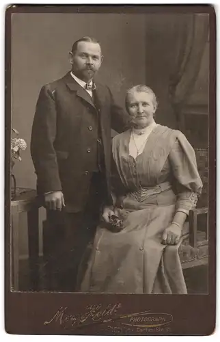 Fotografie Max Holdt, Pirna a /E., Garten-Strasse 31, Portrait älteres Paar in zeitgenössischer Kleidung