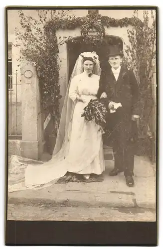 Fotografie unbekannter Fotograf und Ort, Portrait junges Paar in Hochzeitskleidung mit Blumenstrauss