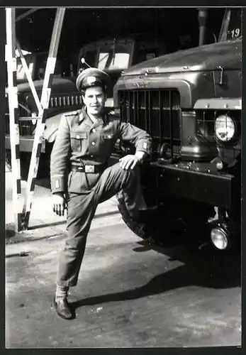 Fotografie DDR, Soldat der NVA in Uniform posiert mit LKW Lastwagen Ural 375