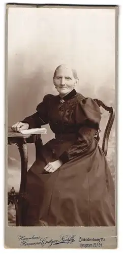 Fotografie Hermann Conitzer Nachfl., Brandenburg a /H., Hauptstrasse 22-24, Portrait ältere Dame im Kleid mit Buch