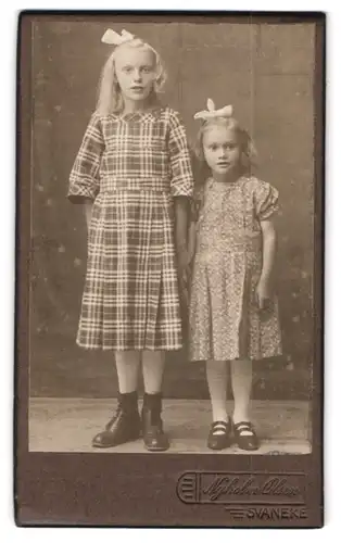 Fotografie Nyholm Olsen, Svaneke, Portrait zwei blonde Mädchen in Sommerkleidern mit Haarschleife