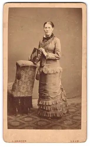 Fotografie J. Hansen, Nexö, junge Frau im gerafften Biedermeierkleid mit Fotoalbum in der Hand