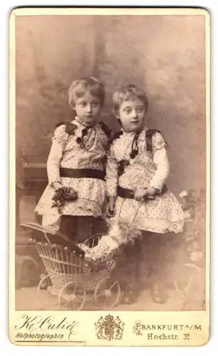 Fotografie Katharina Culie, Frankfurt a. M., Hochstr. 32, zwei Mädchen in Pünktchenkleidern mit Puppe im Puppenwagen
