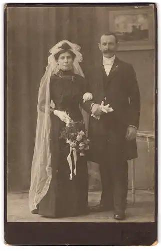 Fotografie R. Rosenkranz, Mügeln, Königstr. 32, Portrait Brautpaar im schwarzen Hochzeitskleid und Anzug