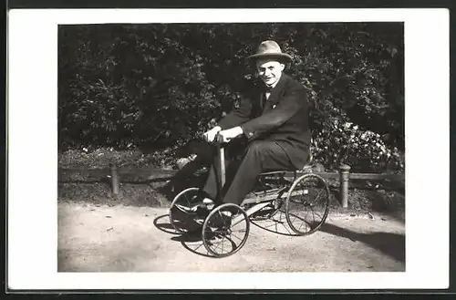 Foto-AK Paul Kaser fährt als junger Mann auf einem mit einem alten Tretauto