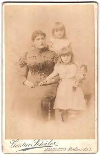 Fotografie Gustav Schüler, Magdeburg, Berlinerstrasse 9, Portrait bürgerliche Dame und zwei Mädchen mit Puppe