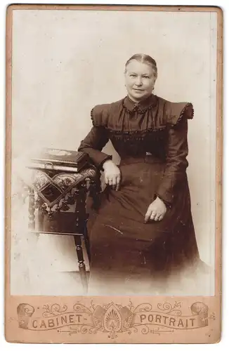 Fotografie unbekannter Fotograf und Ort, Portrait Dame im Biedermeierkleid mit Fotoalbum sitzend im Atelier