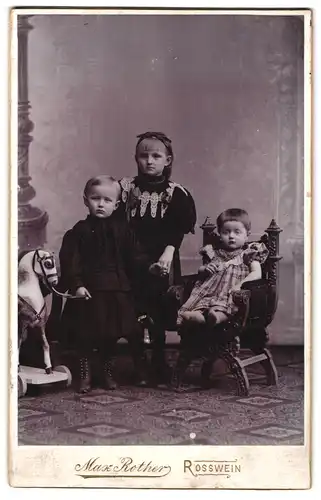 Fotografie Max Rother, Rosswein, Mittel-Strasse 488, Portrait zwei Mädchen und Kleinkind in Kleidern mit Spielzeugpferd