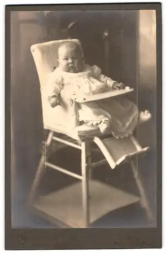 Fotografie W. Dalchow, Egeln, Breiteweg 76, Portrait süsses Baby im Kleid im Hochstuhl
