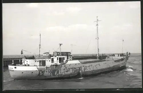 Fotografie Frachtschiff Malacia in Fahrt neben Hafenmole