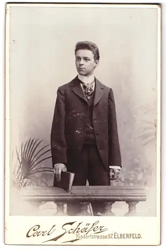 Fotografie Carl Schäfer, Elberfeld, Kipdorfstrasse 57, Portrait junger Herr im Anzug mit Buch in der Hand