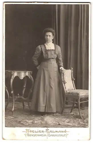 Fotografie Atelier Erdmann, Darmstadt, Dame mit starrem Blick nebst Mobiliar