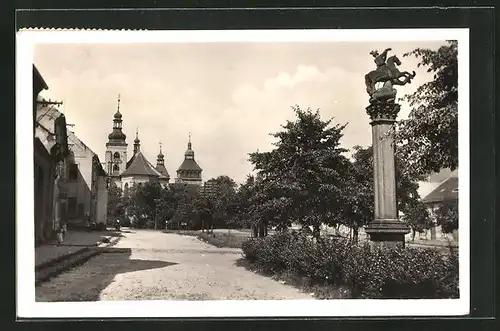 AK Smecno, Strassenpartie am Denkmal mit Blick zur Kirche