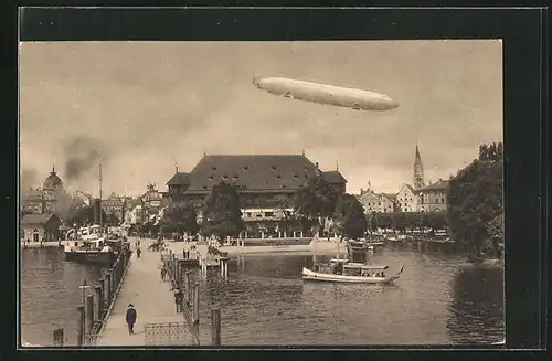 AK Konstanz, auf der Landungsbrücke im Hafen, Zeppelin über der Stadt