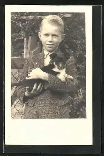 Foto-AK Knabe mit Welpen im Arm
