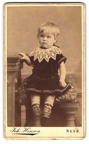 Fotografie Joh. Hansen, Nexö, Ferskesögade, Portrait süsses Kleinkind im Samtkleid mit Spitzenkragen