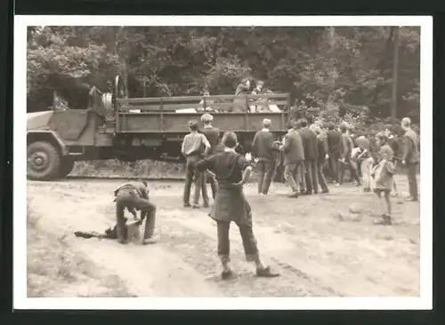 Fotografie Lastwagen der Bundeswehr und Zivilisten auf einem Waldweg