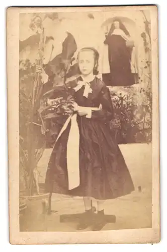 Fotografie J. Davicce, Ort unbekannt, Portrait junges Mädchen im Kleid als Novize in einem Kloster